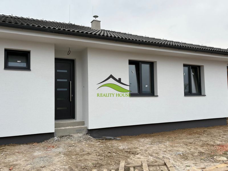 A family house in Michalovce on Hlavná Street with a white facade and black doors.