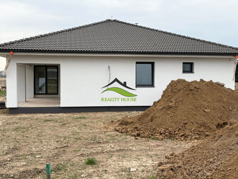 A family house on Hlavná Street in Michalovce, next to a pile of soil and a terrace.