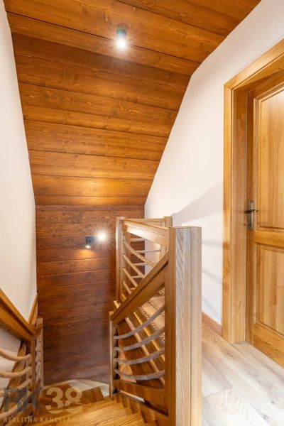 Wooden staircase with rope railing in a family house.