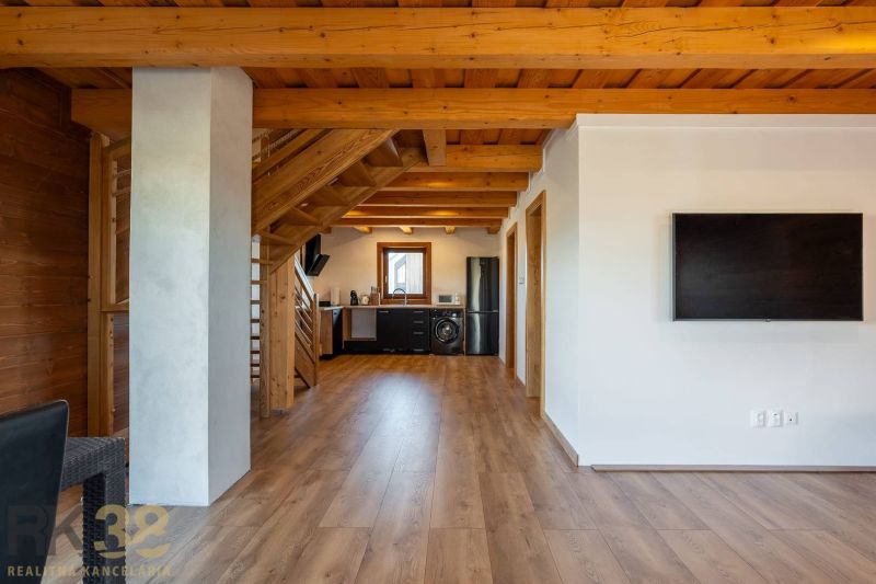 Interior of a family house with a kitchen, staircase, and wooden decor flooring.
