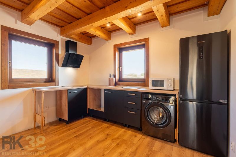 A kitchen in a family house with a wooden decor floor and black appliances.