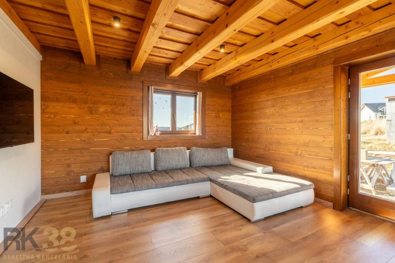 A family house with wooden cladding, a sofa, and a floor with a wooden design.