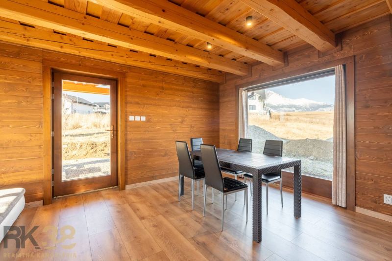 Dining area in a family house with a wooden decor floor and a view of the mountains.