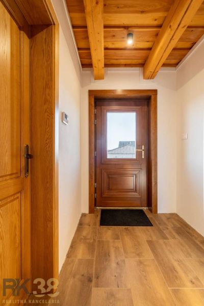 Interior doors in a family house with a wooden decor floor and visible beams.