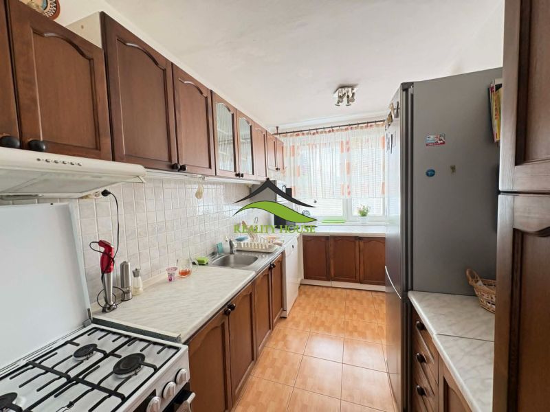 A kitchen in a 4-room apartment with dark cabinets and light walls.