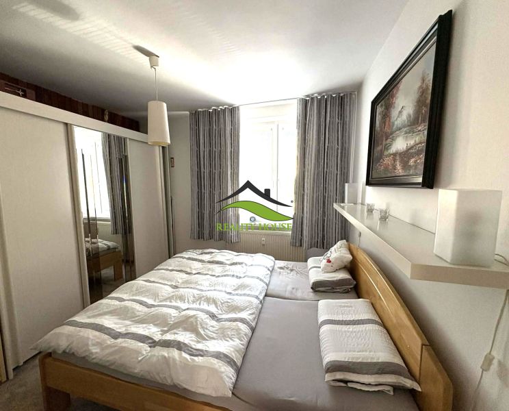 Bedroom in a 4-room apartment with a large bed, wardrobe, and decorative painting.