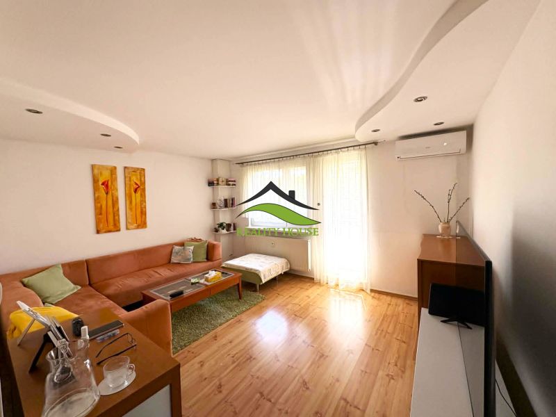 Living room with a sofa, wood-patterned flooring, and light-colored furniture in a 4-room apartment.