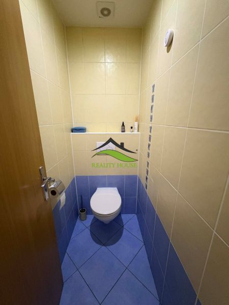 A bathroom in a 4-room apartment with a combination of yellow and blue tiles.