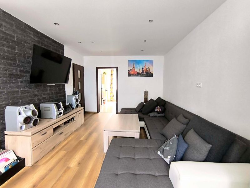 Living room with wood-patterned flooring, a sofa set, and a TV in a 3-room apartment.