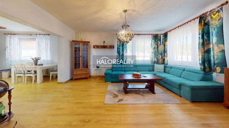 Living room in a family house with a spacious sofa and a floor with a wooden decor.