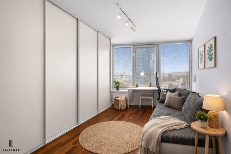 A room in a 3-room apartment with a comfortable sofa, a table, and a floor with a wooden decor.