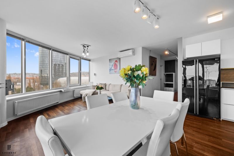 Interior of a 3-room apartment with a dining table and a wooden decor floor.