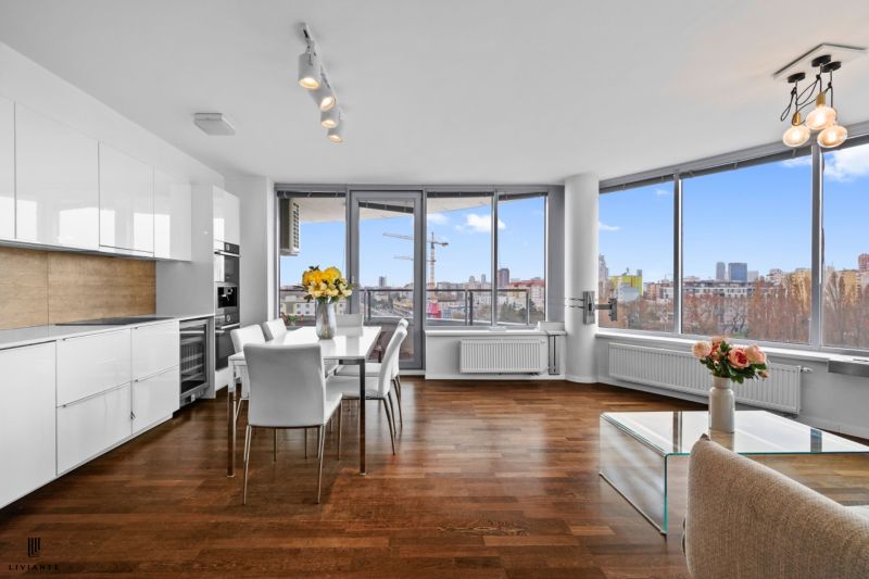A kitchen in a 3-room apartment with white cabinets and a wood-patterned floor.