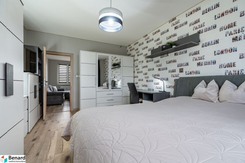 Bedroom in a 2-room apartment with a wooden decor floor and modern furniture.