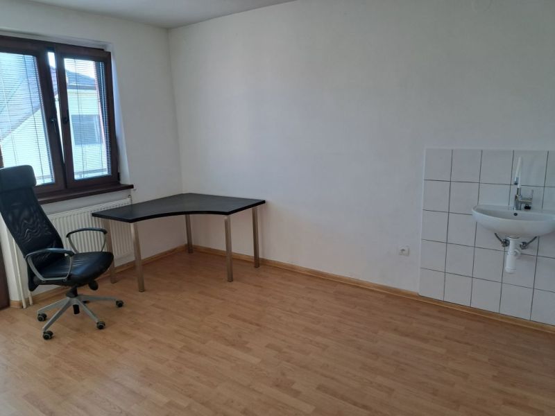 Offices with wood-patterned flooring, a desk, and a chair.