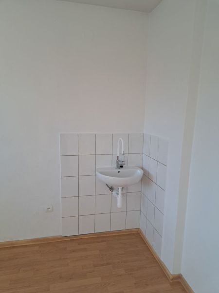 Offices with a sink, white walls, and a floor with a wood decor.