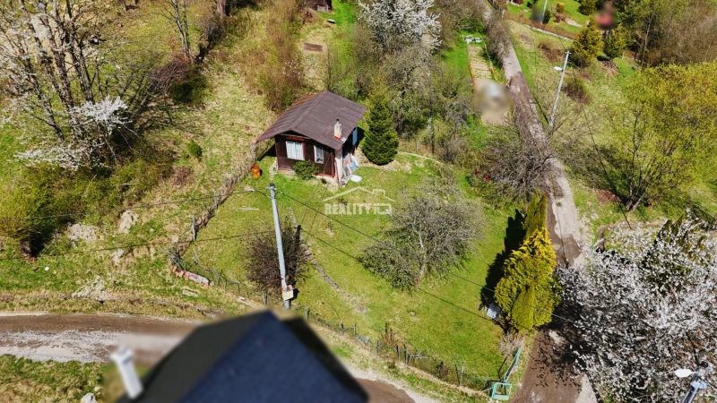 A wooden cottage surrounded by trees and nature in Krásno nad Kysucou.