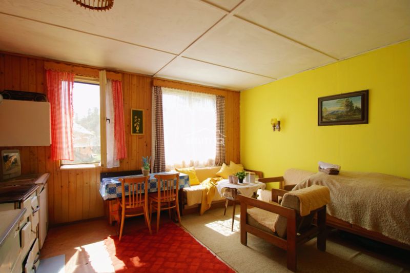 The interior of the cottage with light wooden decor, cozy seating, and retro tiles.