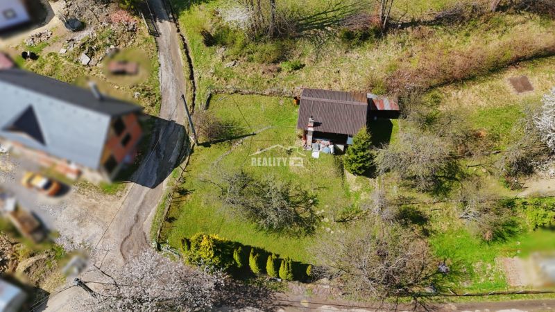 A cottage in Krásno nad Kysucou surrounded by greenery with trees and a garden.