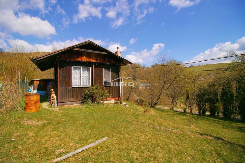 A wooden cabin surrounded by greenery on a plot in Krásno nad Kysucou, suitable for living.