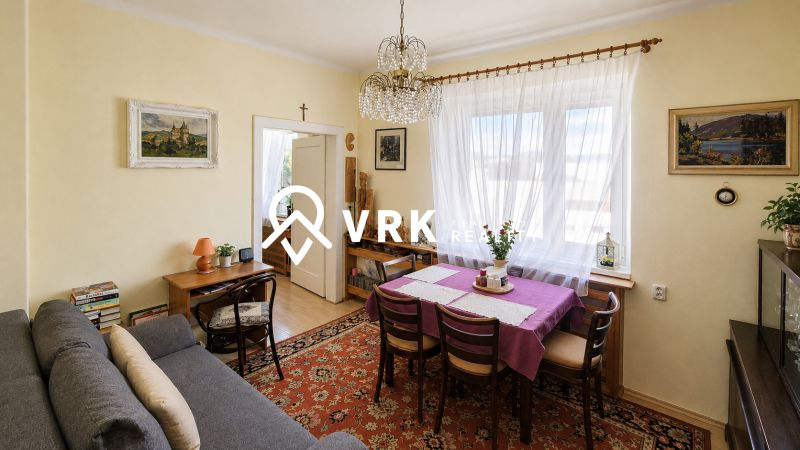Living room in a family house with a sofa, dining area, and decorations.