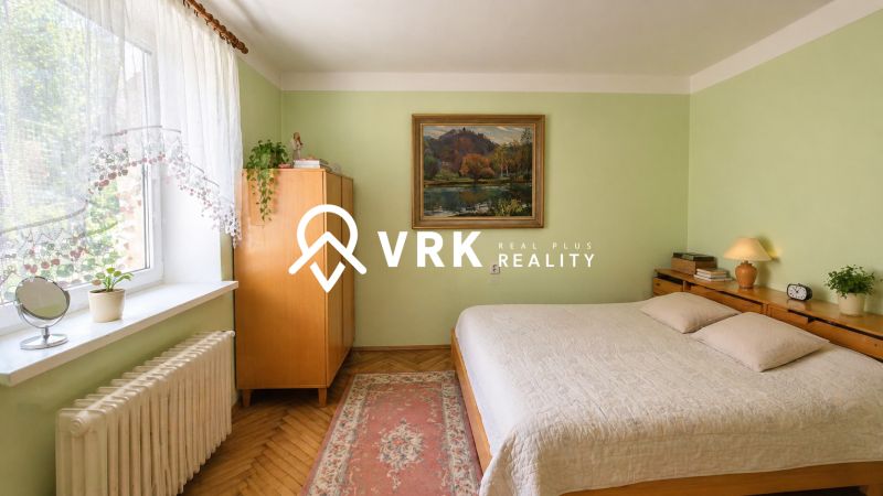 Bedroom in a family house with a painting, wooden furniture, and a floor with a wooden decor.