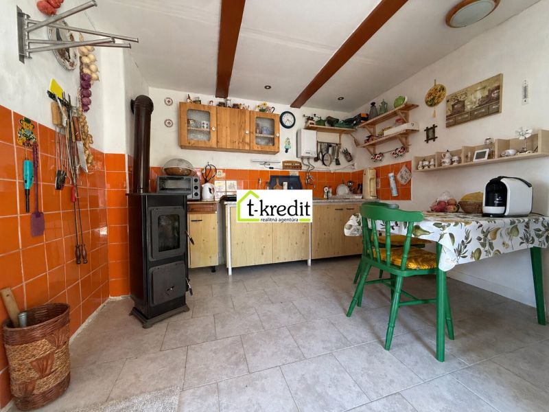 A kitchen in a family house with tiles and orange tiles.
