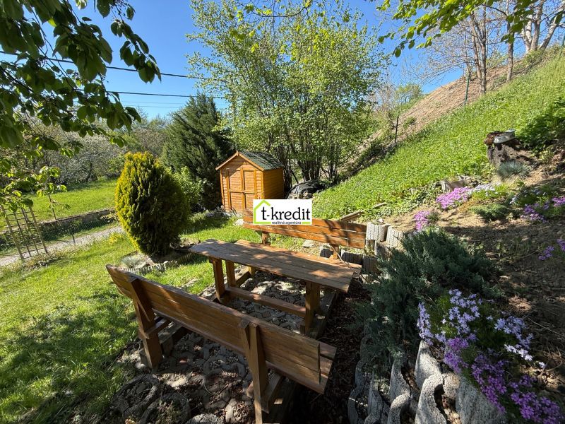 A garden at a family house in Čaradice, a wooden gazebo with a table and benches surrounded by nature.