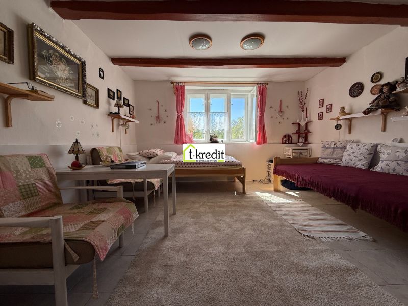 Living room in a family house with sofas, a window, and decorations on the wall.