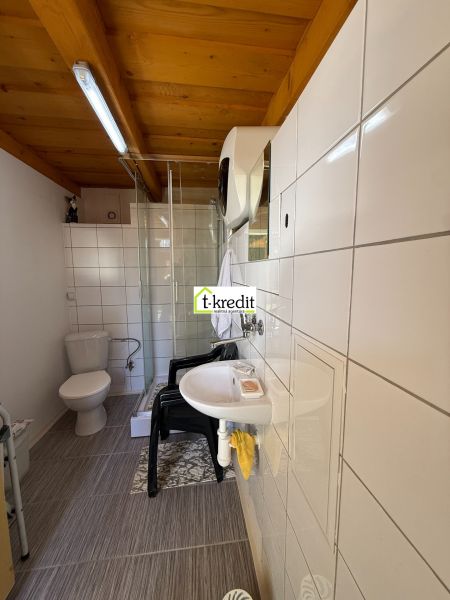 A bathroom in a family house with white tiles and a shower corner.
