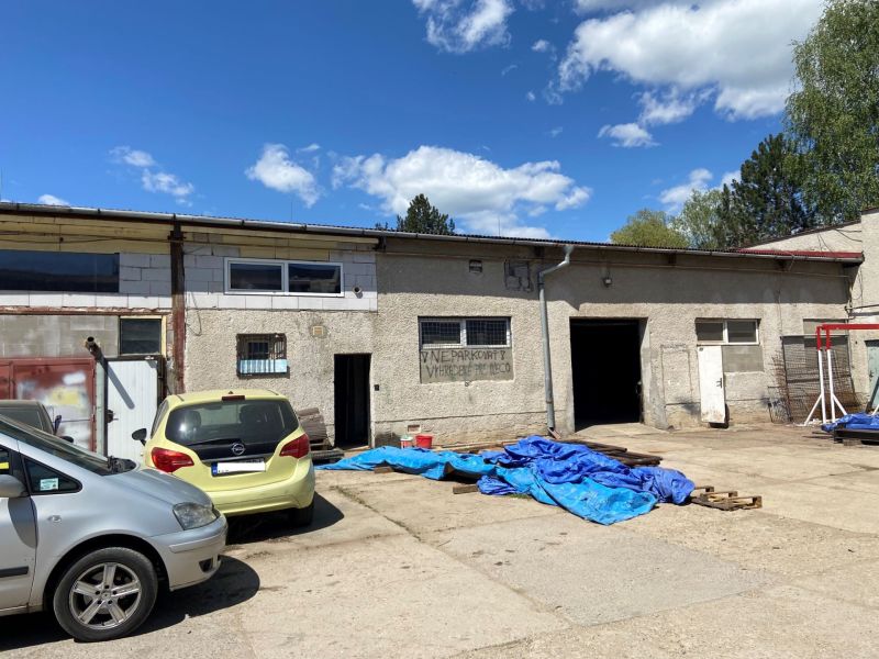 The courtyard of special properties on Košická Road in Rimavská Sobota with cars and tarpaulins.