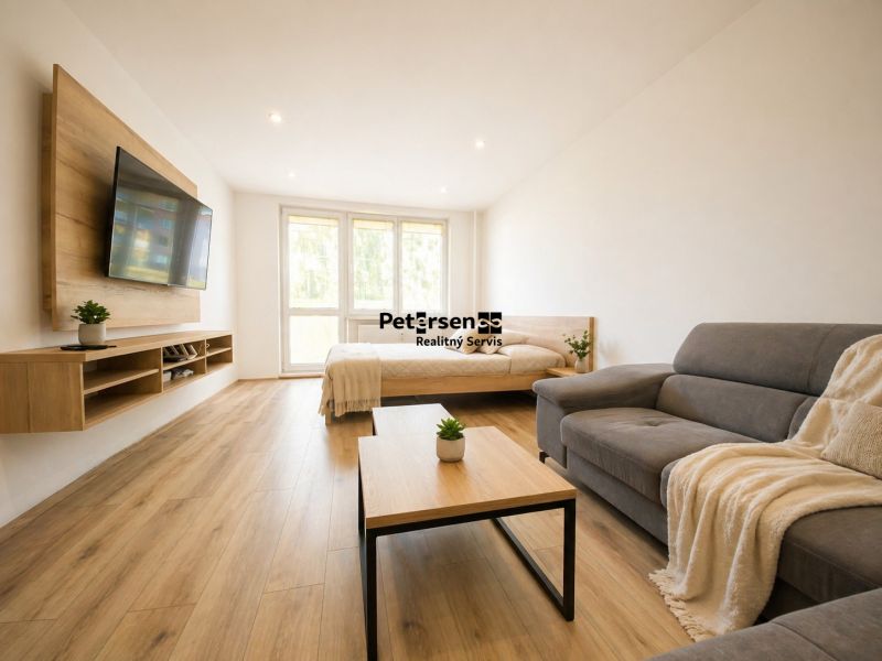 A bright living room with a TV on the wall in a 2-room apartment with wooden floor decor.