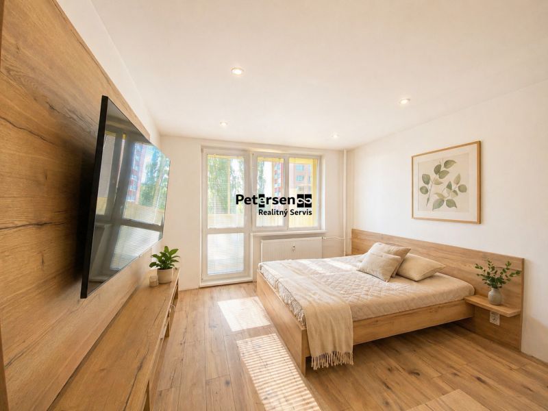 Bedroom in a 2-room apartment with a bed, television, and wooden decor flooring.