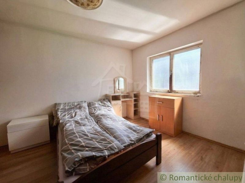 Bedroom in a family house with a bed and furniture, floor with wooden decor.