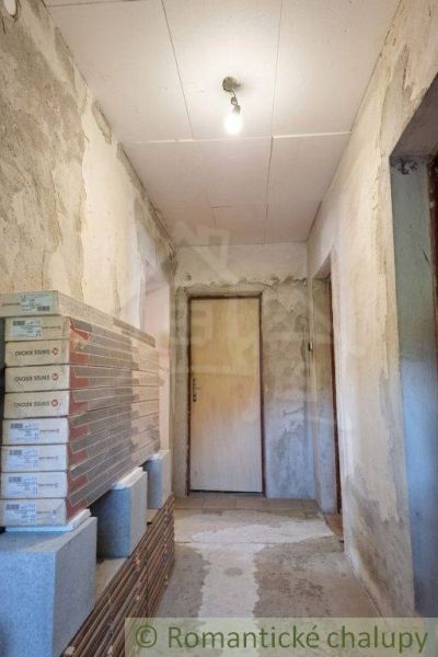 A hallway in a family house with unfinished walls and doors, prepared packages of laminate.