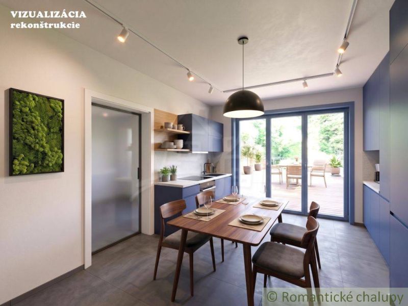 A kitchen in a family house with blue cabinets and access to the terrace.