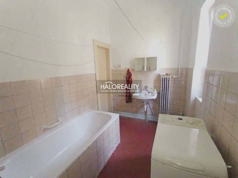 Bathroom in a 2-room apartment with a bathtub, sink, and washing machine.