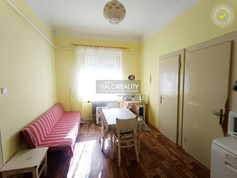 Interior of a 2-room apartment with a wooden decor floor, dining table, and sofa.