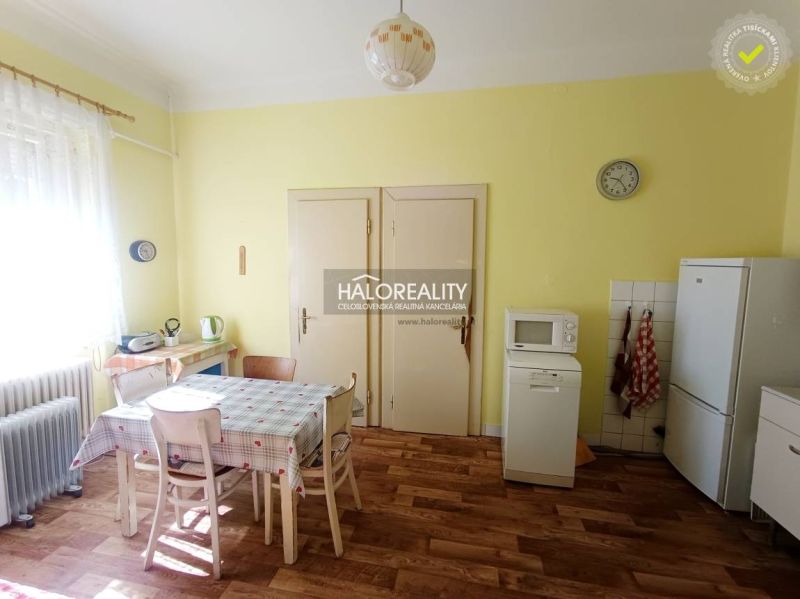 A kitchen in a 2-room apartment with a wooden decor floor and a dining table.