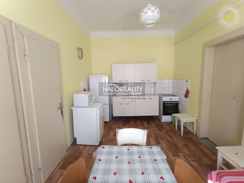 A kitchen in a 2-room apartment with a wooden decor floor and basic appliances.