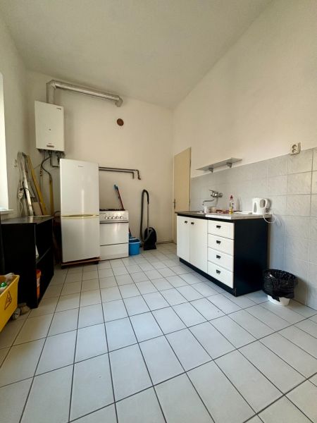 Offices with a kitchenette, tiled floor, stove, refrigerator, and boiler.