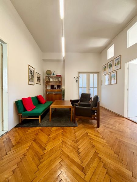 Offices with a sofa and chairs, floor with wood decor, walls with decorations.