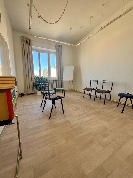 Offices with wood-patterned flooring, chairs, and a board, pleasant lighting.