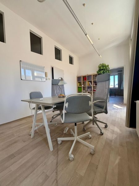 Offices with wood-patterned flooring, white walls, and seating.