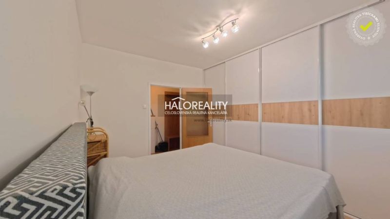Bedroom with a large built-in wardrobe and bright lighting in a 2-room apartment.