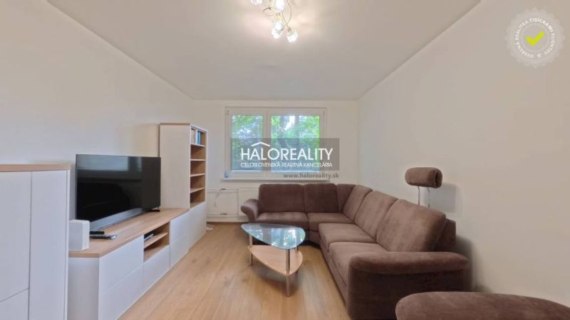 Living room with a brown sofa, television, and wooden decor flooring in a 2-room apartment.