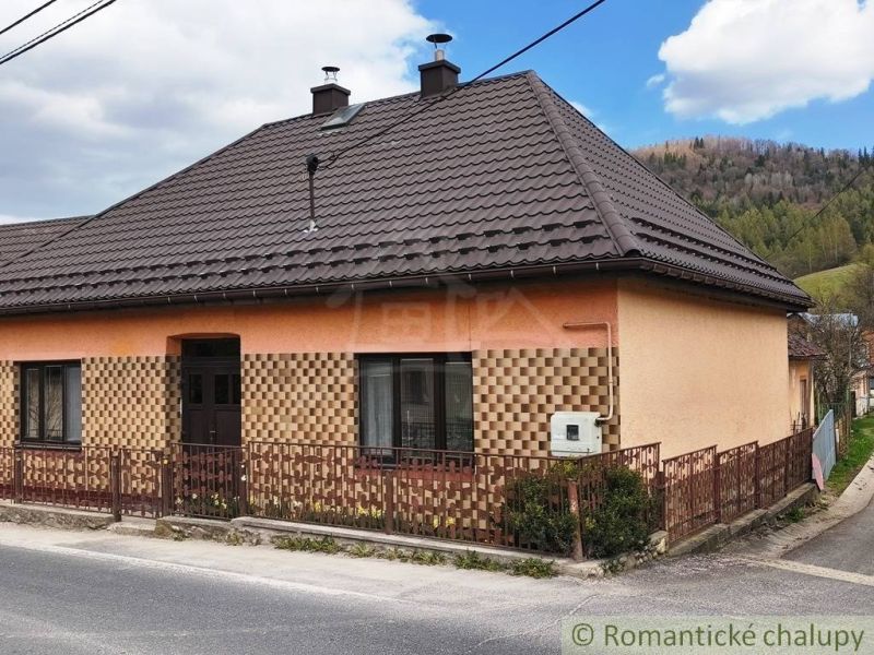 A family house in Reľov with a brown roof and an interesting facade by the road.