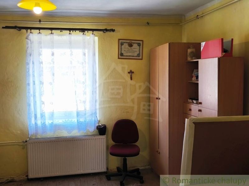 A room in a family house with furniture, a window, and a wooden decor floor.