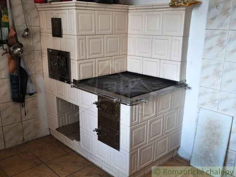 Traditional solid fuel stove in a family house with tiles and cladding.