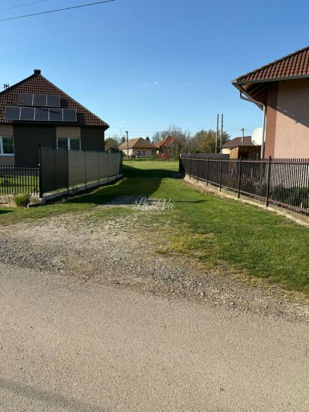 A garden with a lawn between houses in Pozba, suitable for residential plots.
